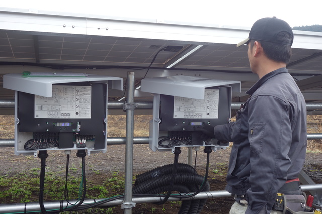 太陽光発電設備を点検する人
